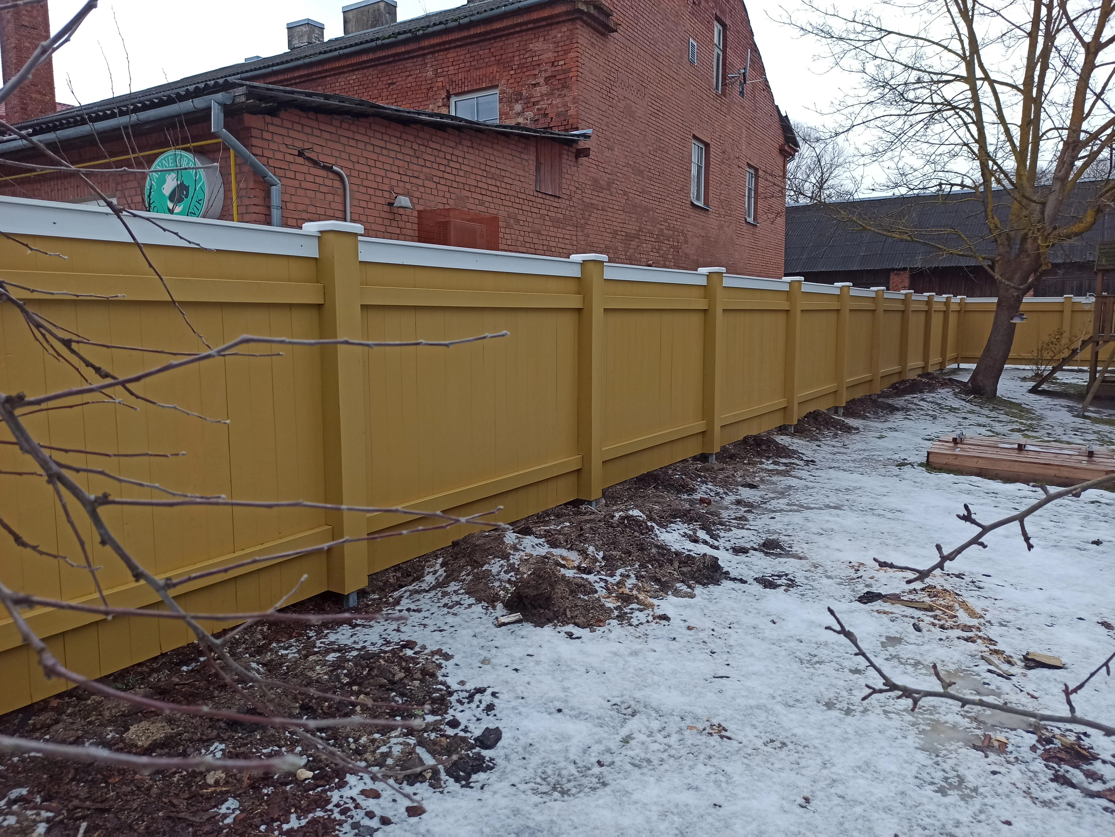 Puitaed - kollane vertikaalne laudis punase tellismaja kõrval talvel