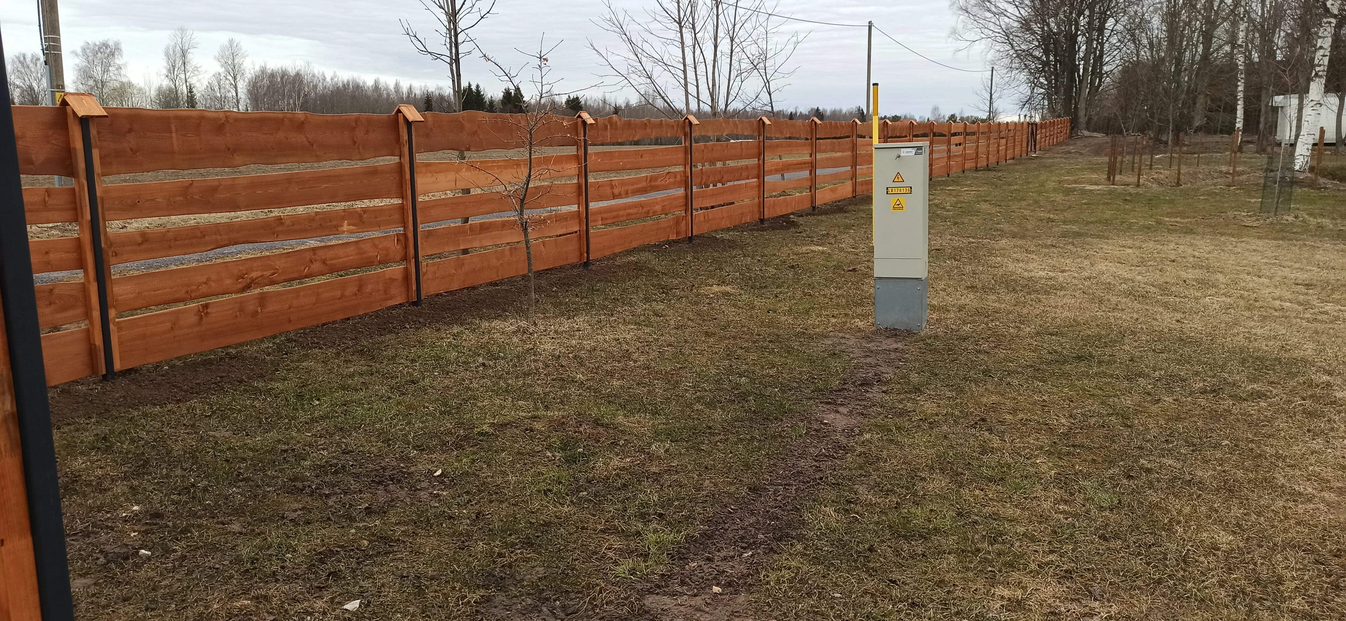 Puitaed - pruun horisontaalne laudis metalpostidel maalapil