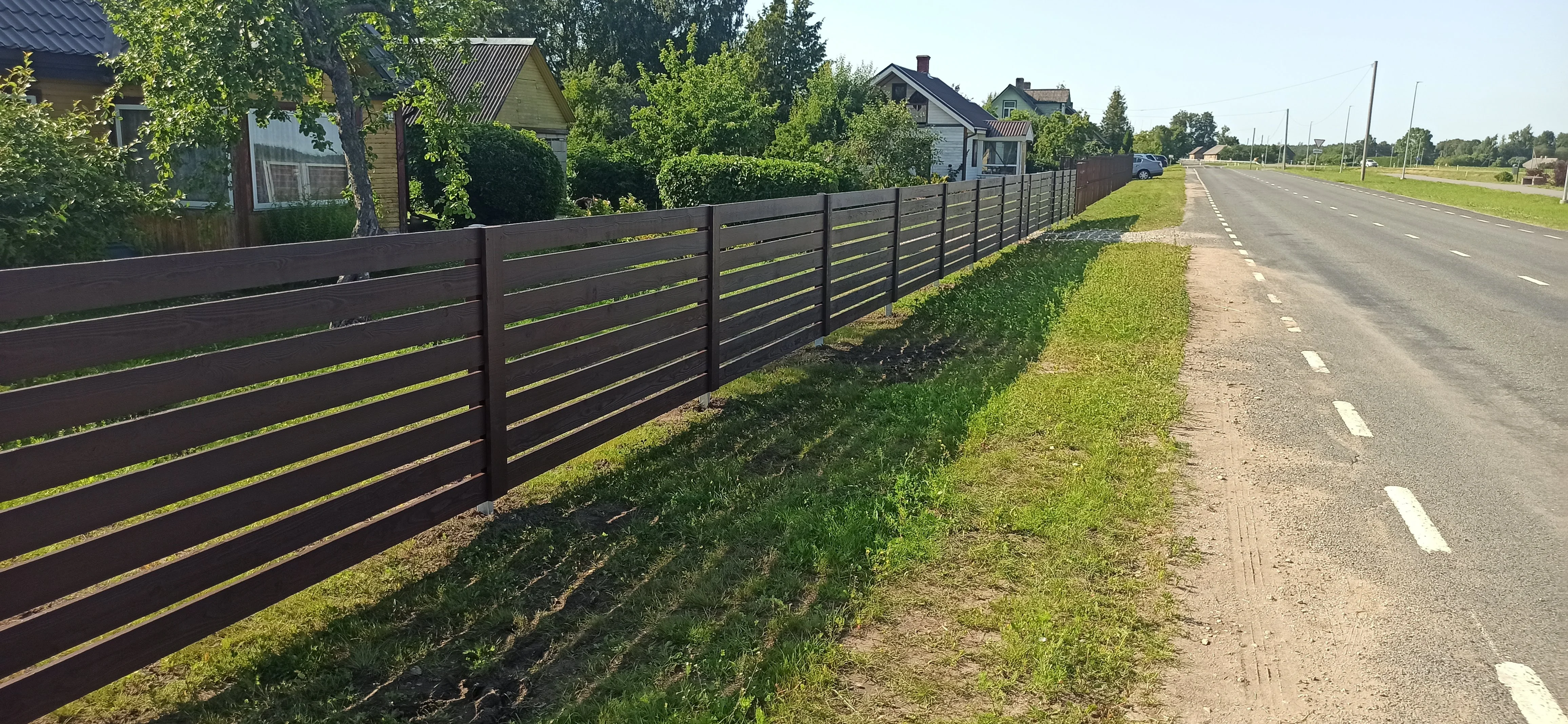 Puitaed - pruun horisontaalne laudis metalpostidel põhitee ääres