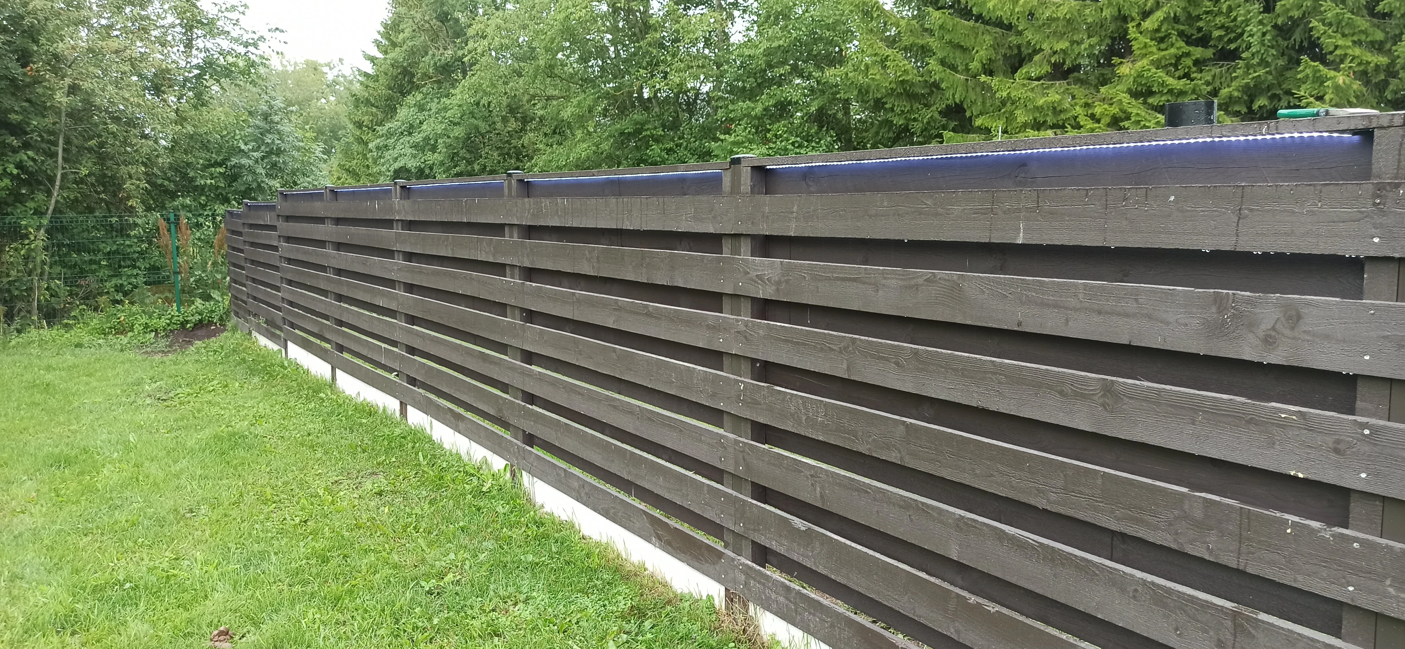 Puitaed - horisontaalne tumehall laudis betoonvundamendiga