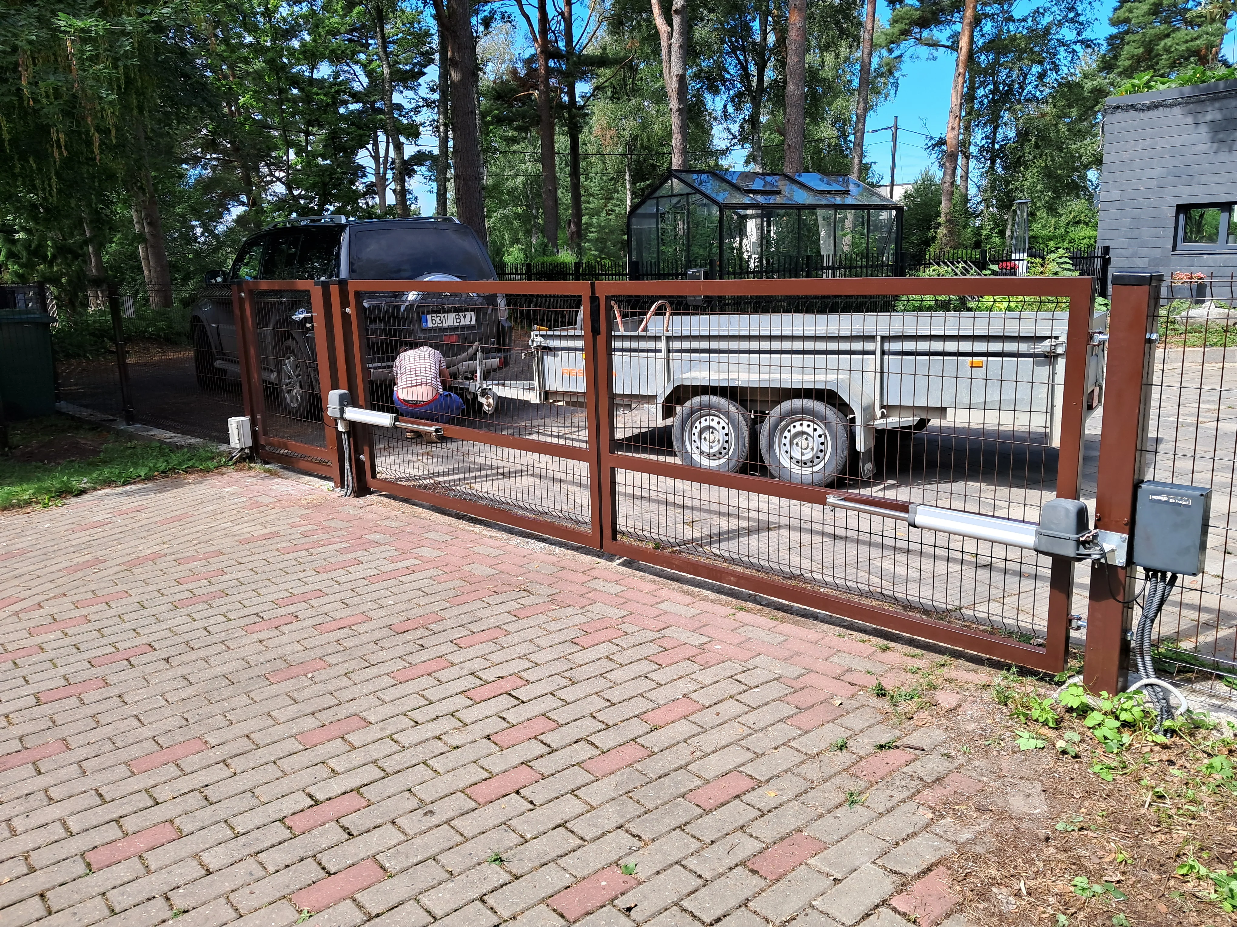 Varav - pruun keevispaneel kahepoolne tiibvärav automaatikamootoritega hoovis