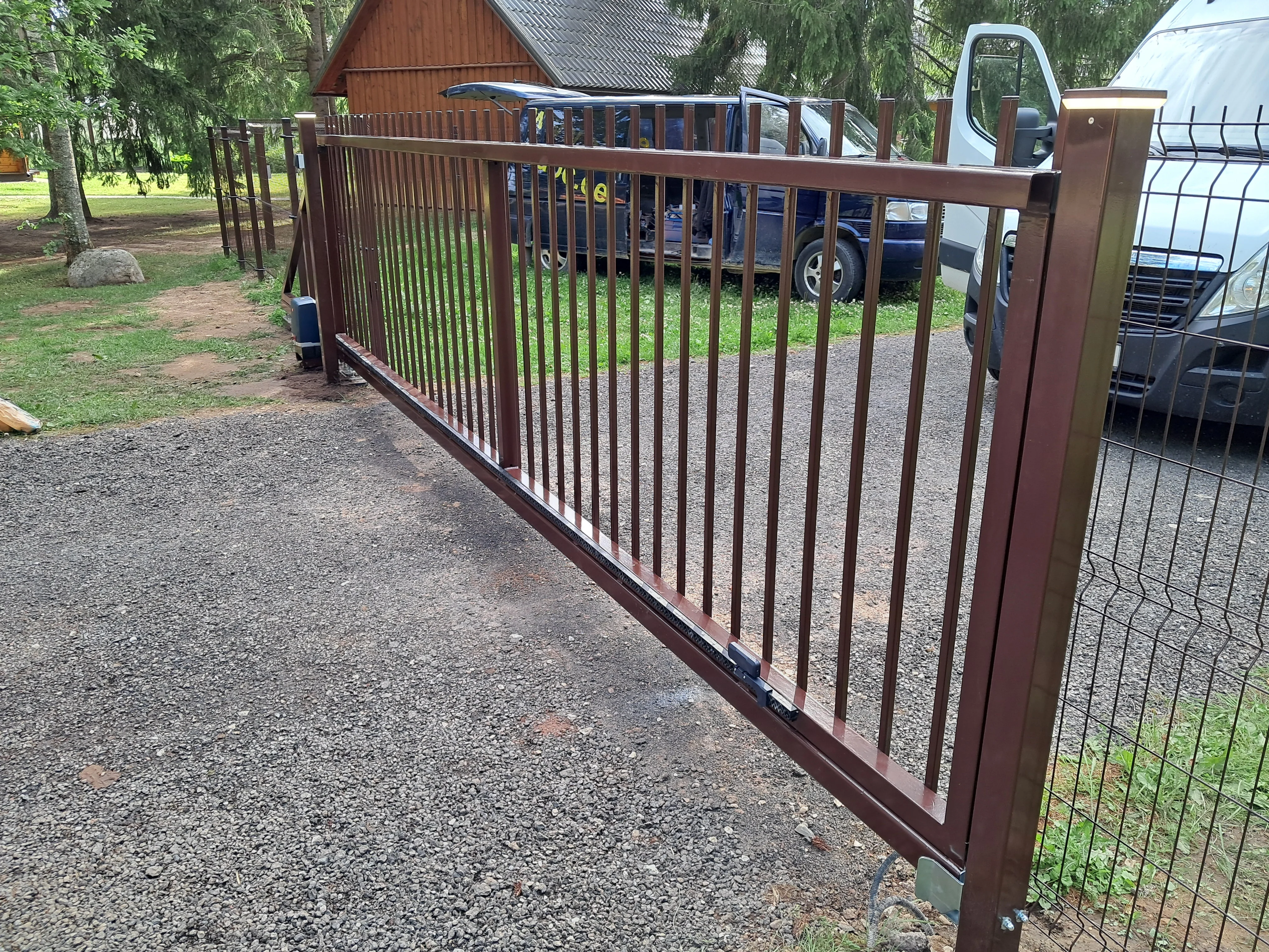 Varav - horisontaalne puitlaudis värav metalpostidel õhtuses valguses