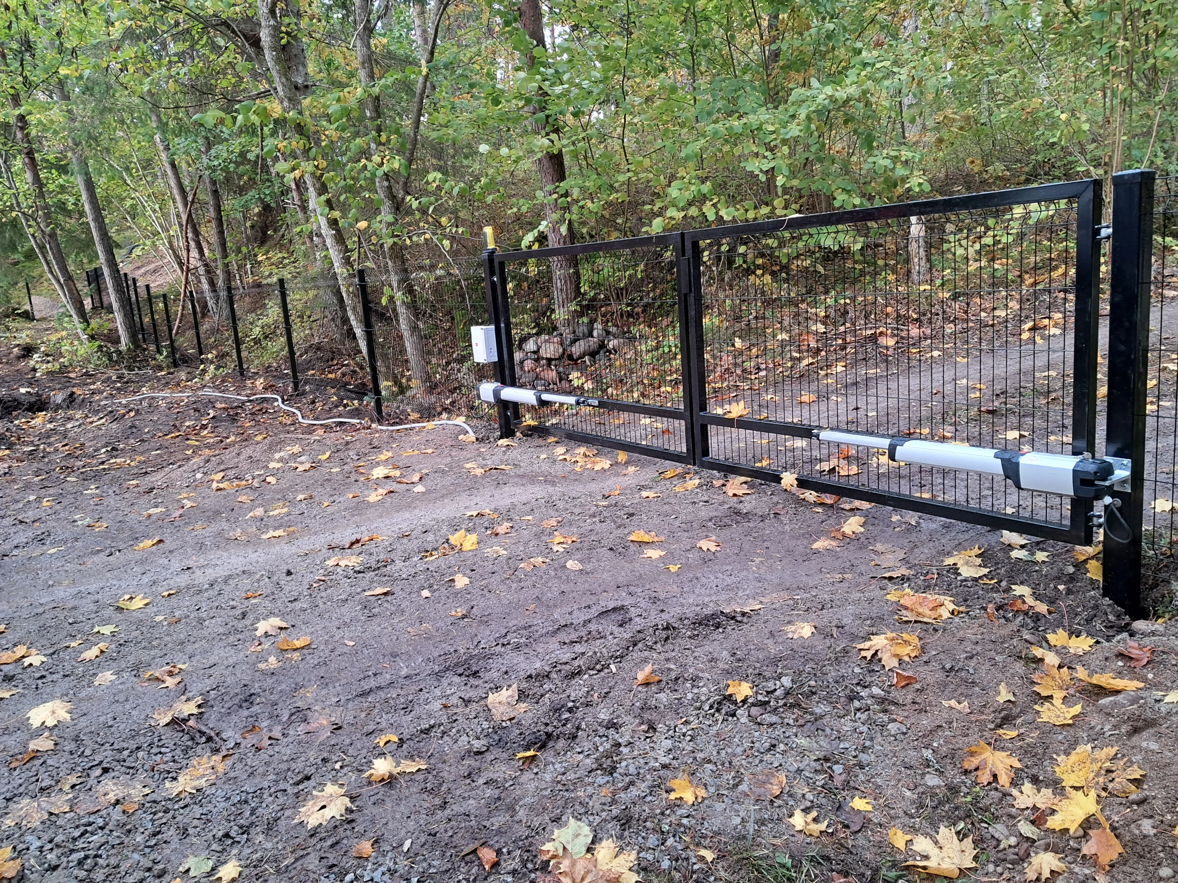 Varav - must keevispaneel kahepoolne värav automaatikamootoritega metsasel kinnistul