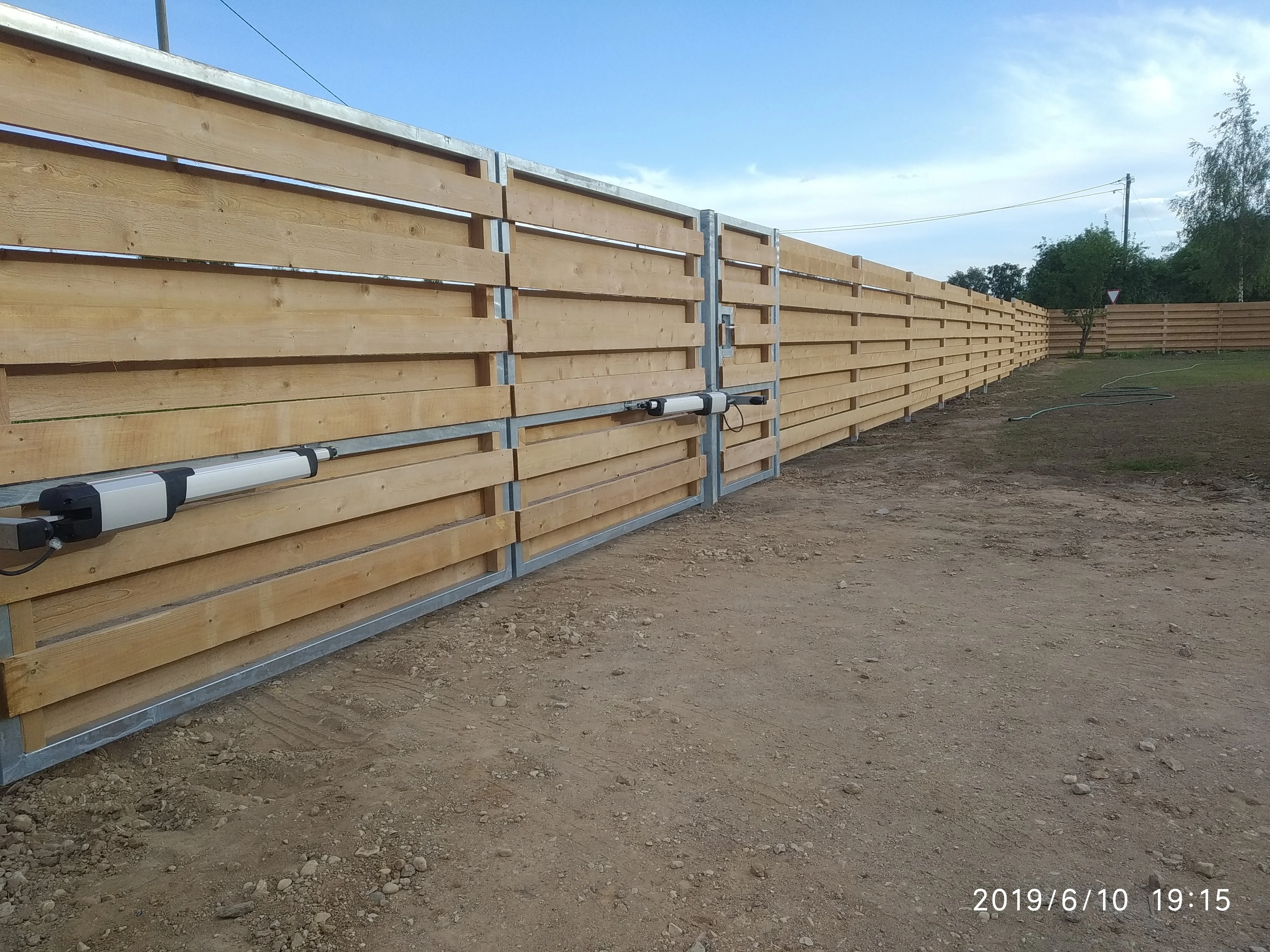 Varav - horisontaalne puitlaudis tiibvärav automaatikamootoritega paigaldamisel