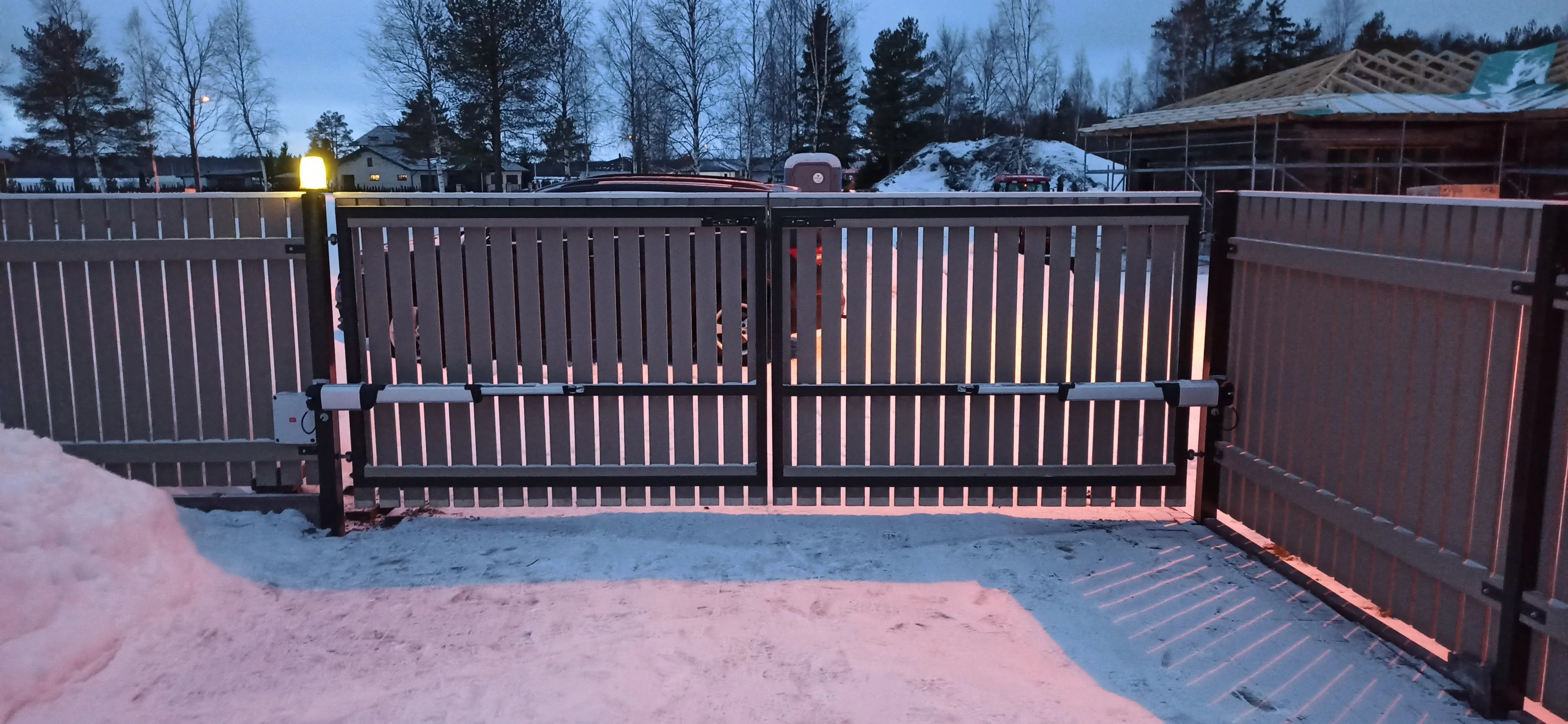 Varav - antratsiithall puitlaudis tiibvärav automaatikamootoritega lumisel ööl